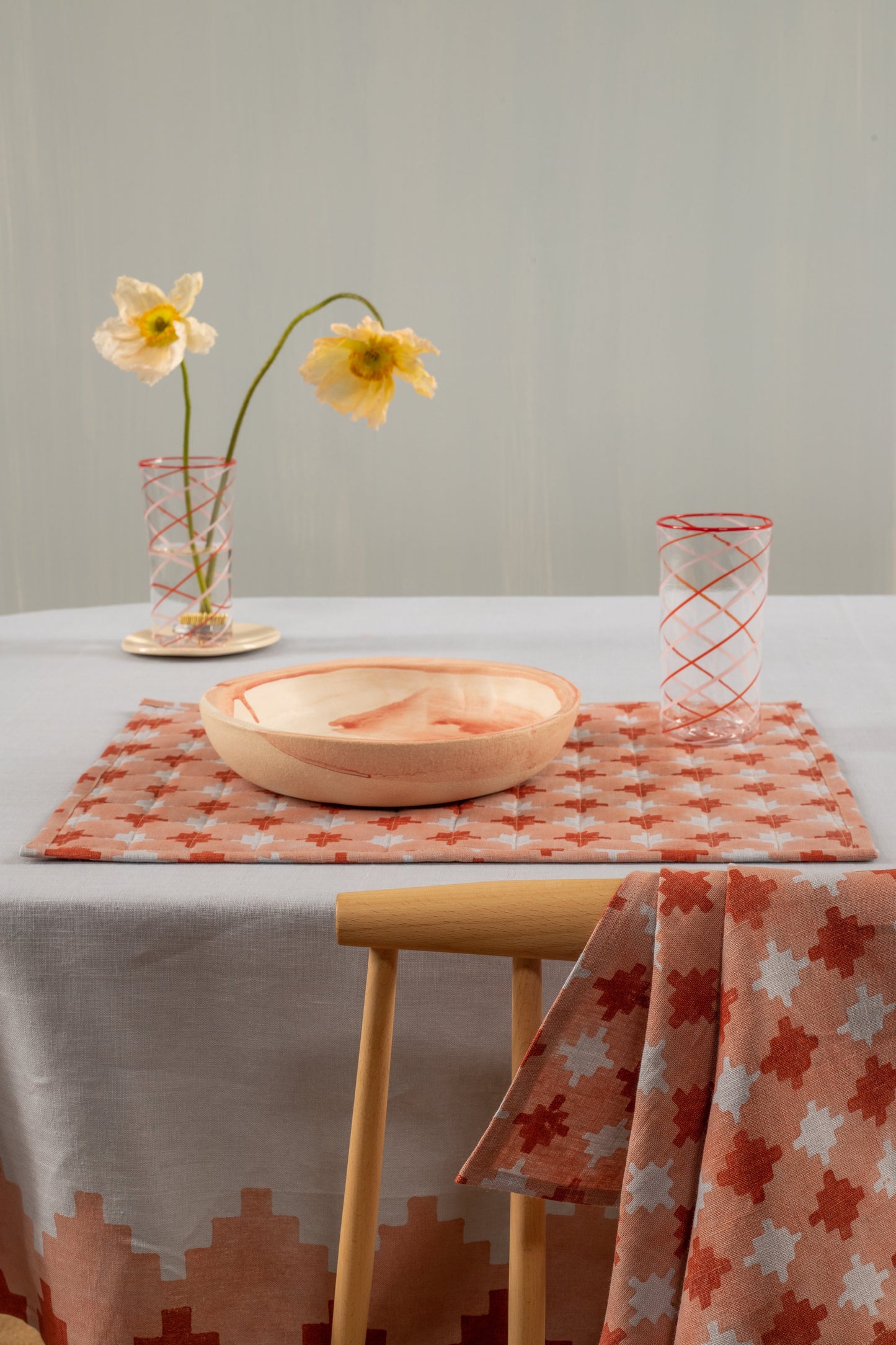 Blue and red placemat with glass and bowl set on top of it