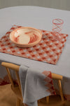 Top angled view of blue and red placemat with glass and bowl set on top of it