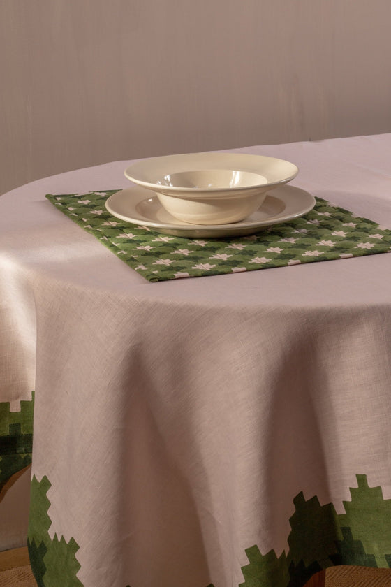 Pink and green placemat under stacked bowl and plate