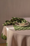 Pink and green napkin partially rolled up in the bowl of a place setting